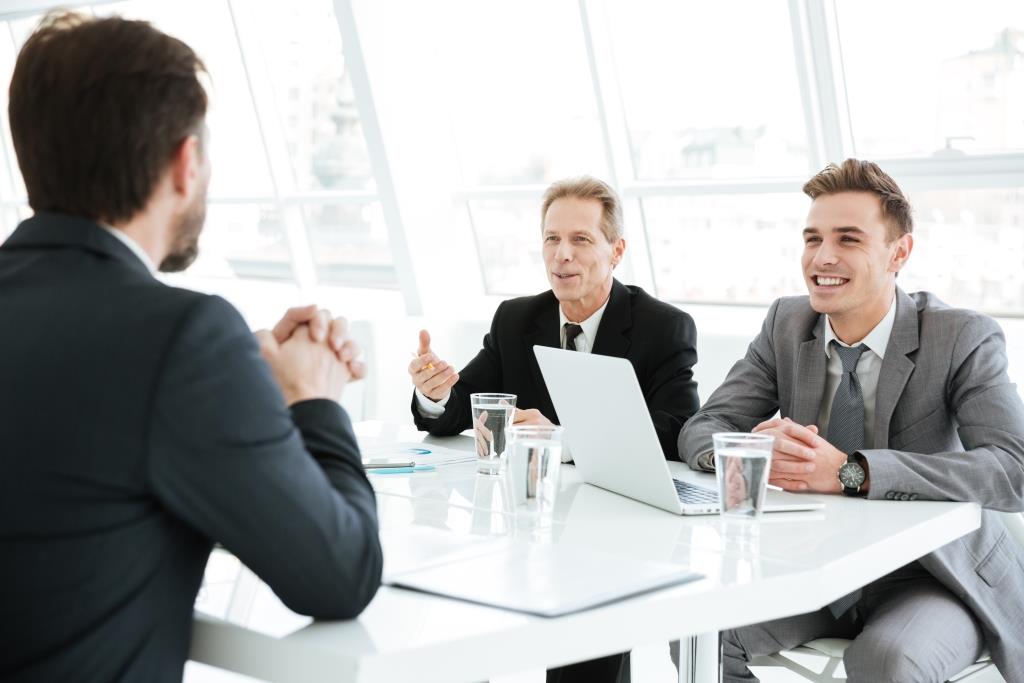 Smiling smart business people working on difficult financial project in office