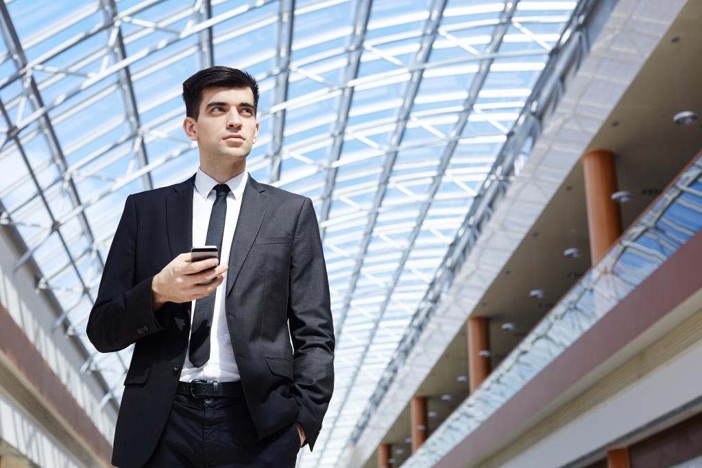 Serious young entrepreneur with smartphone